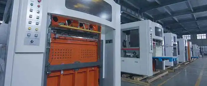 Factory floor showing a modern roll die cutting machine with servo motors on the die and anvil stations